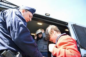 Policjanci prezentują dzieciom sprzęt, którego używają w służbie