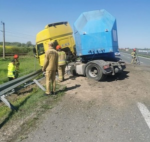 Na zdjęciu przewrócona ciężarówka wokół, której stoją strażacy