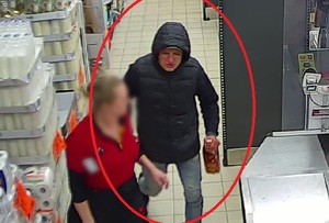 Na ujęciu z kamery monitoringu widać mężczyznę ubranego w ciemną kurtkę, z butelką alkoholu w ręku. Po jego lewej stronie stoi ekspedientka, ubrana w czerwoną koszulkę.