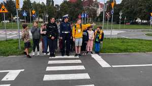 Policjantka z dziećmi na przejściu dla pieszych