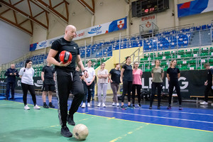 Grupa osób na sali gimnastycznej.